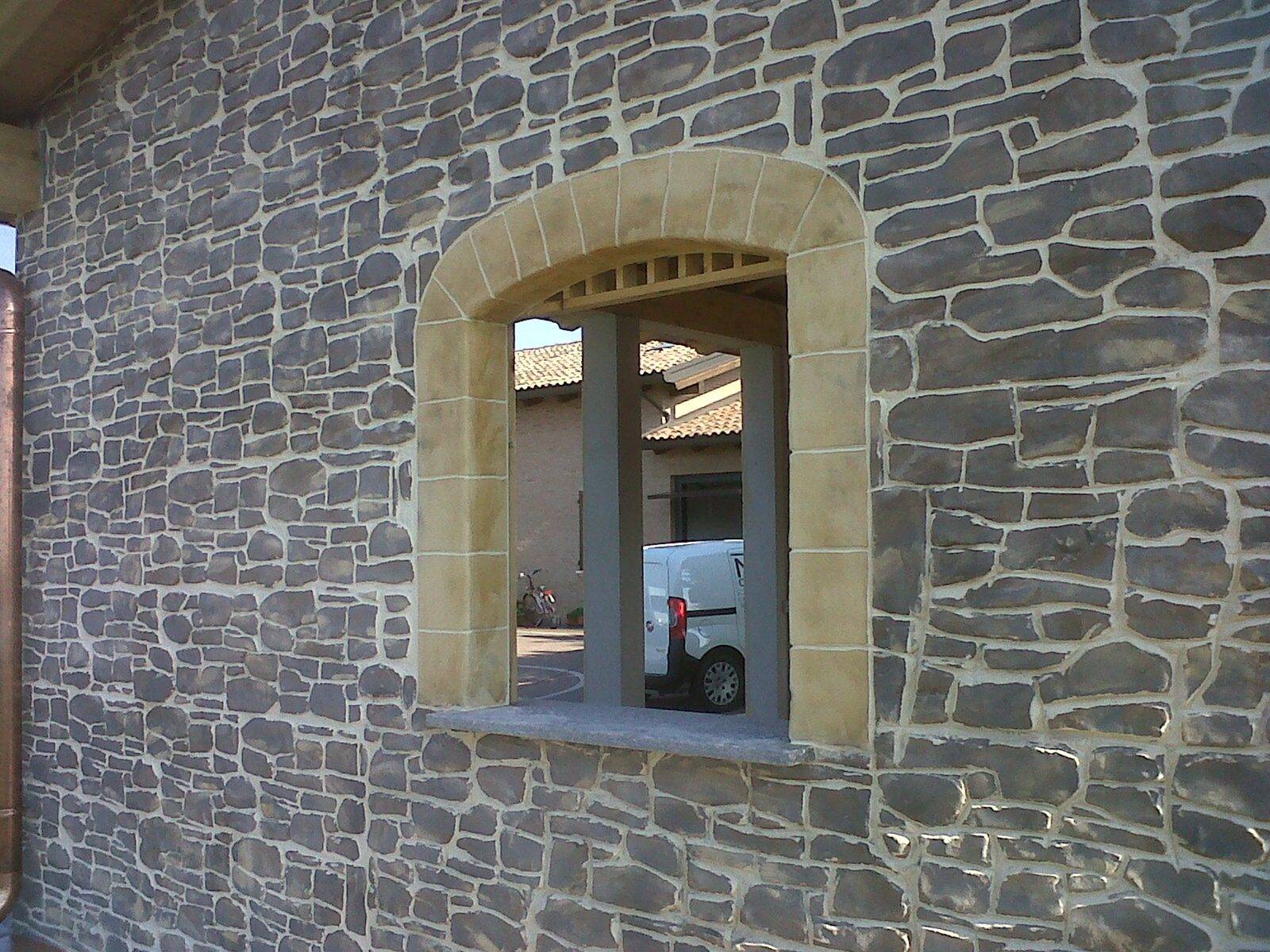Muro in cemento stampato effetto pietra attorno a una finestra
