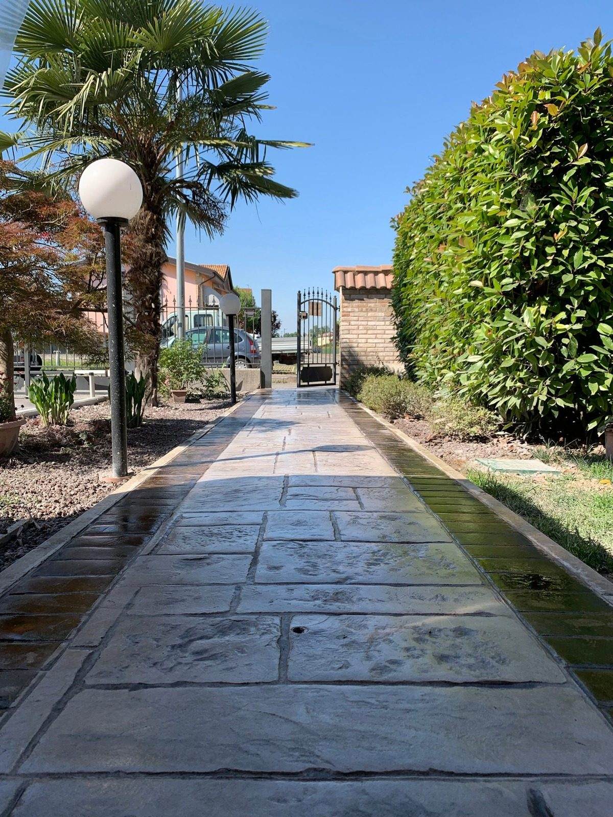Viale condominiale in cemento acidificato con lampioni a Colorno (PR)