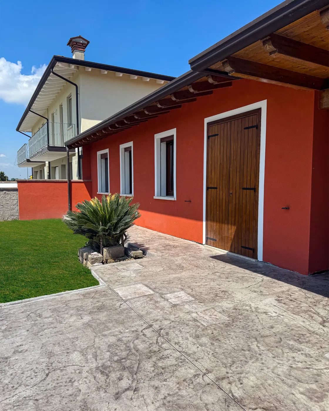 Corte di una casa rossa pavimentata in cemento stampato a Casaloldo (MN)