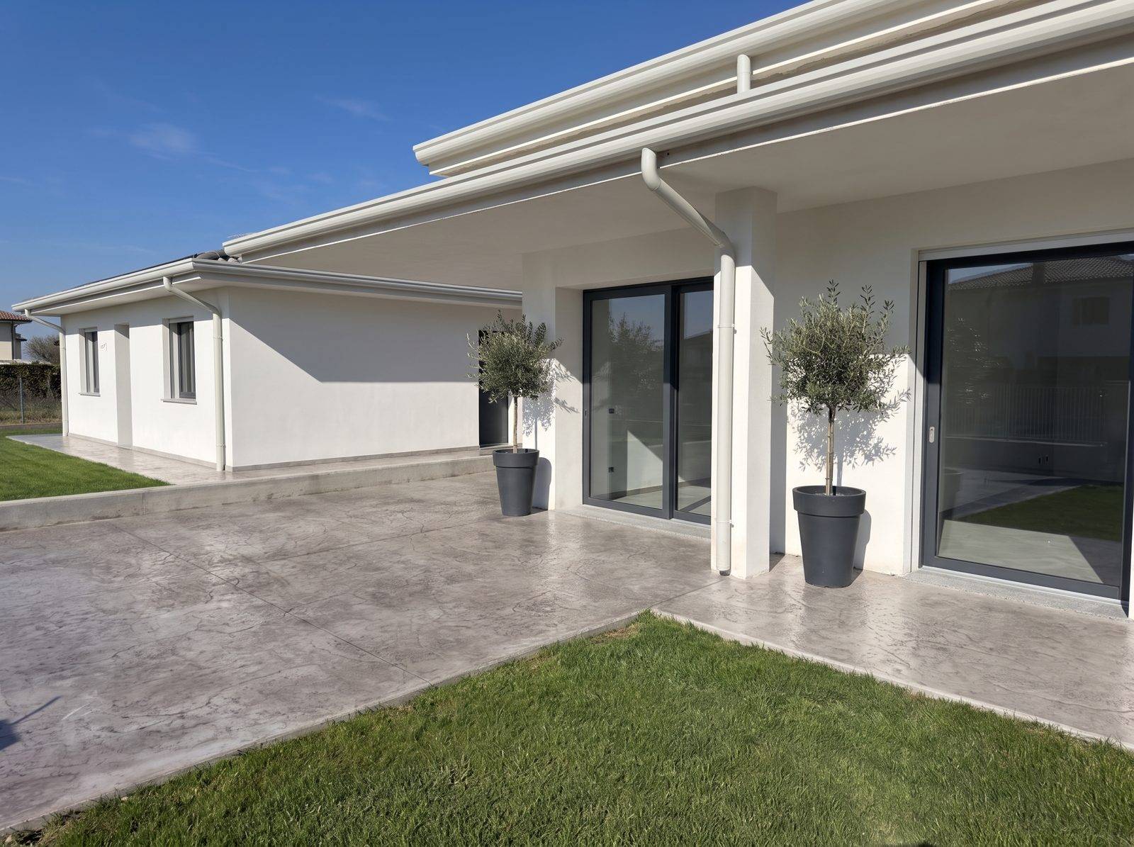Ingresso della casa con cemento stampato effetto roccia e prato