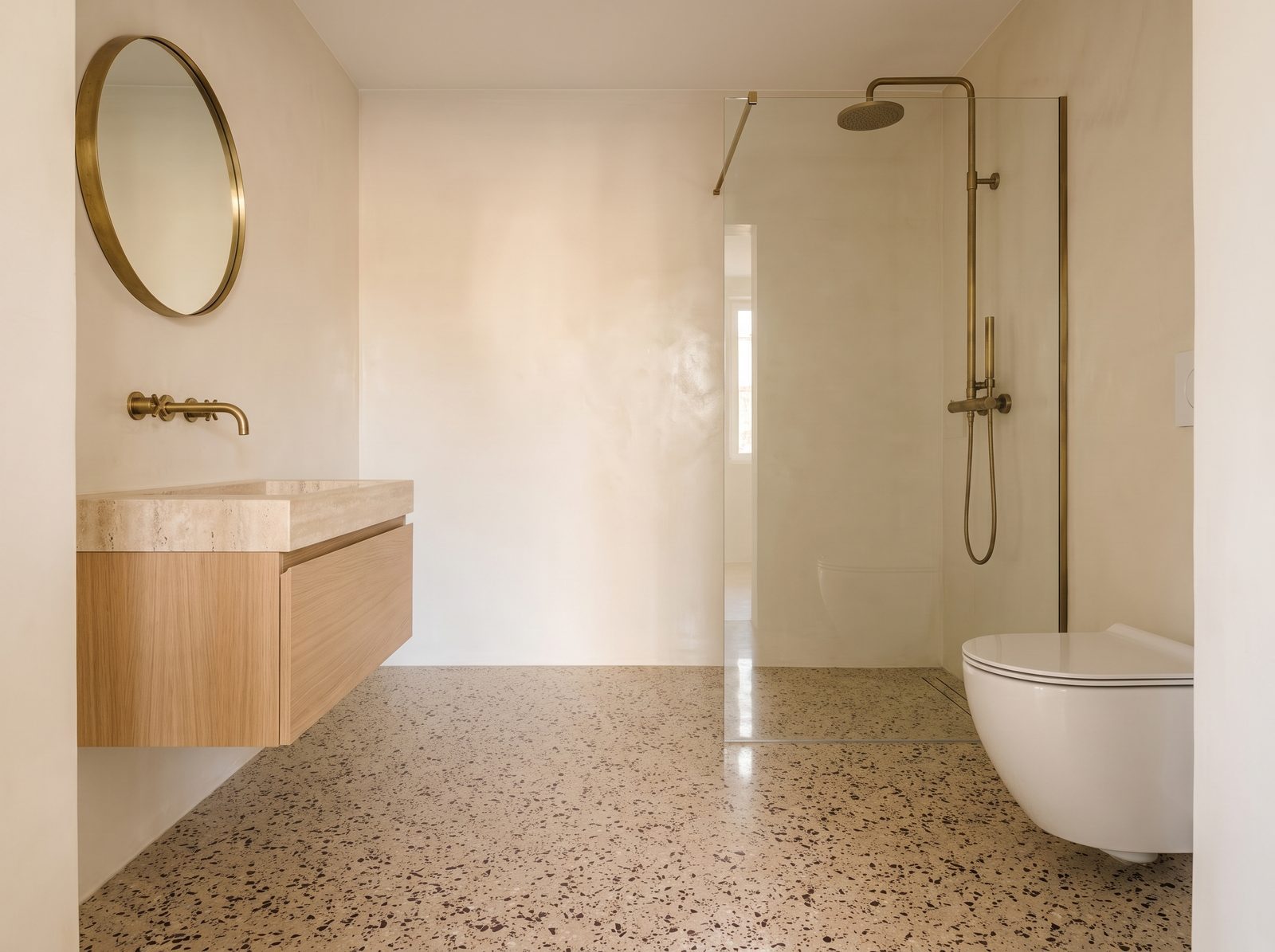 Bagno con lo stesso pavimento alla veneziana del salone, senza cambio di materiale