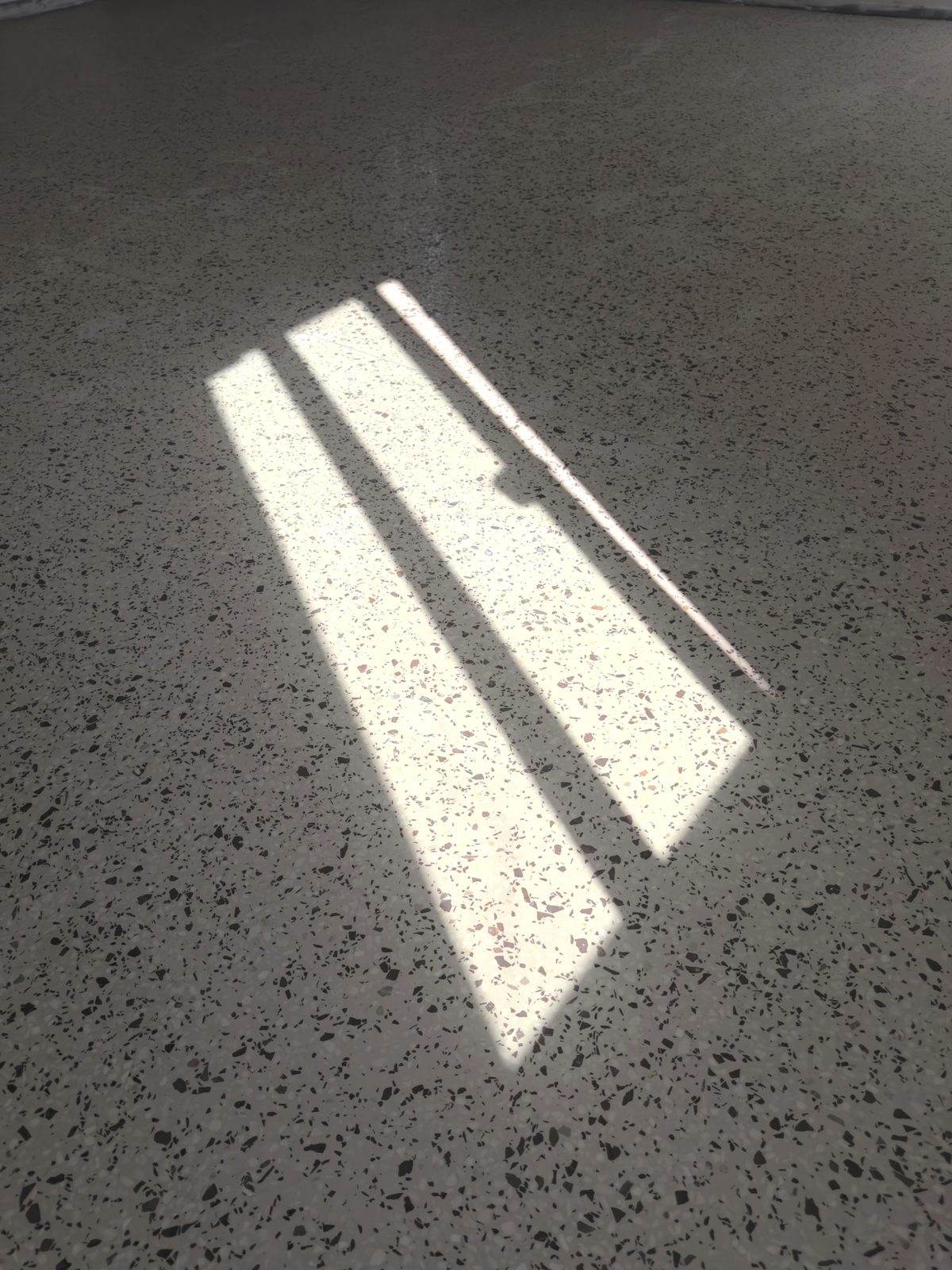 Luce naturale che attraversa un pavimento alla veneziana levigato a specchio