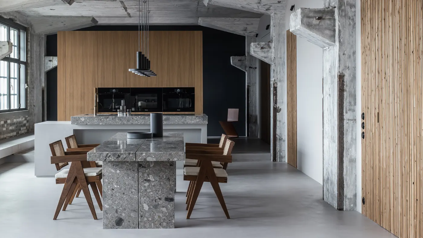 Loft con pavimento in microcemento e tavolo in legno