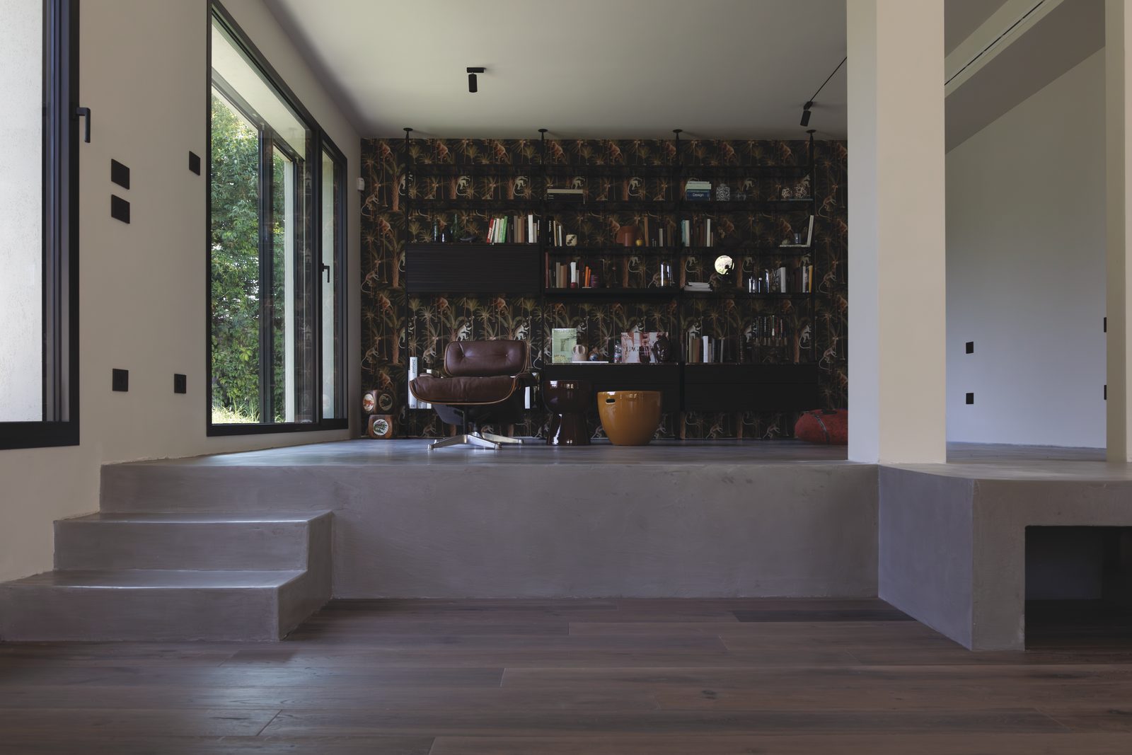 Gradone in microcemento davanti alla parete libreria