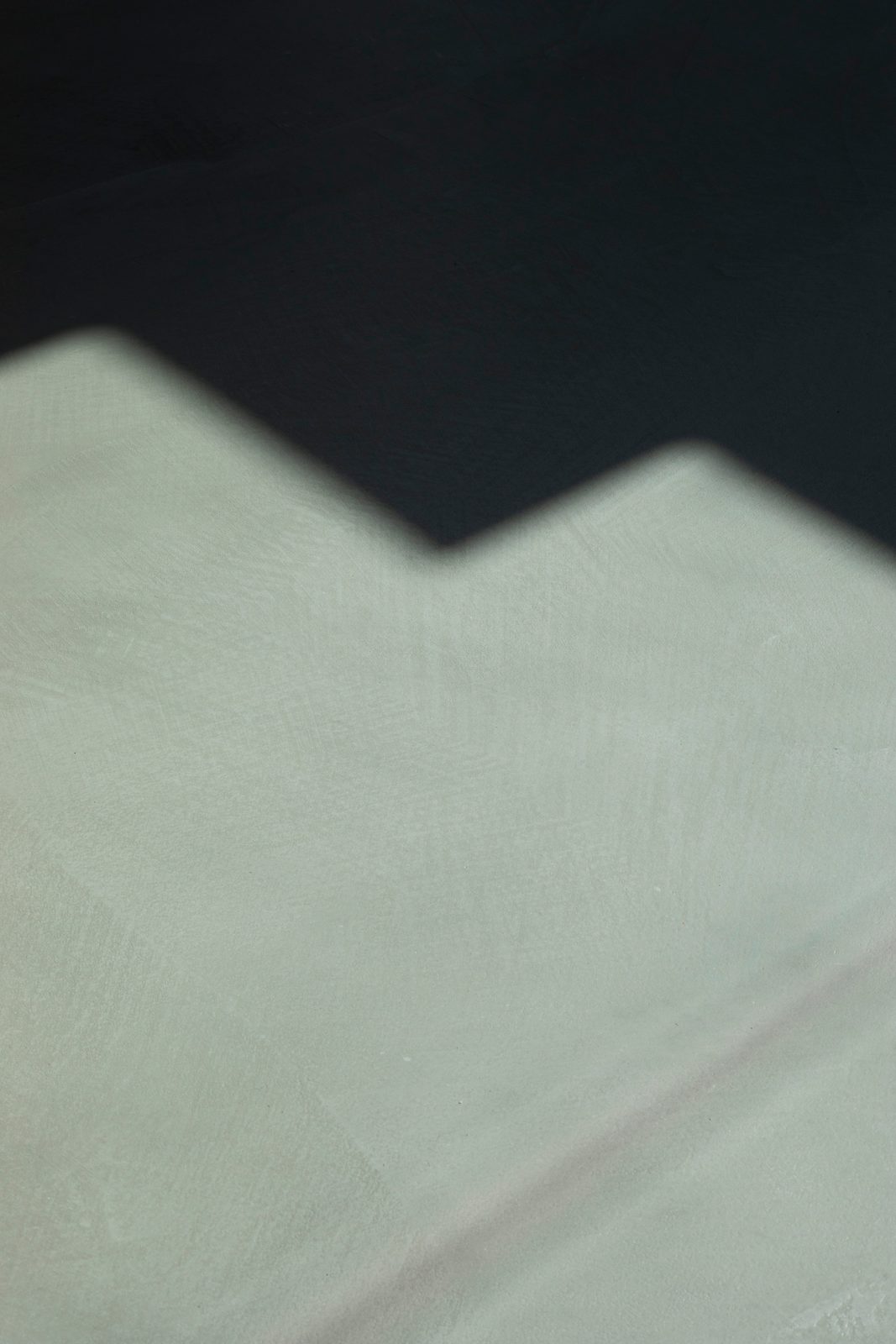 Pavimento in microcemento attraversato dalla luce radente