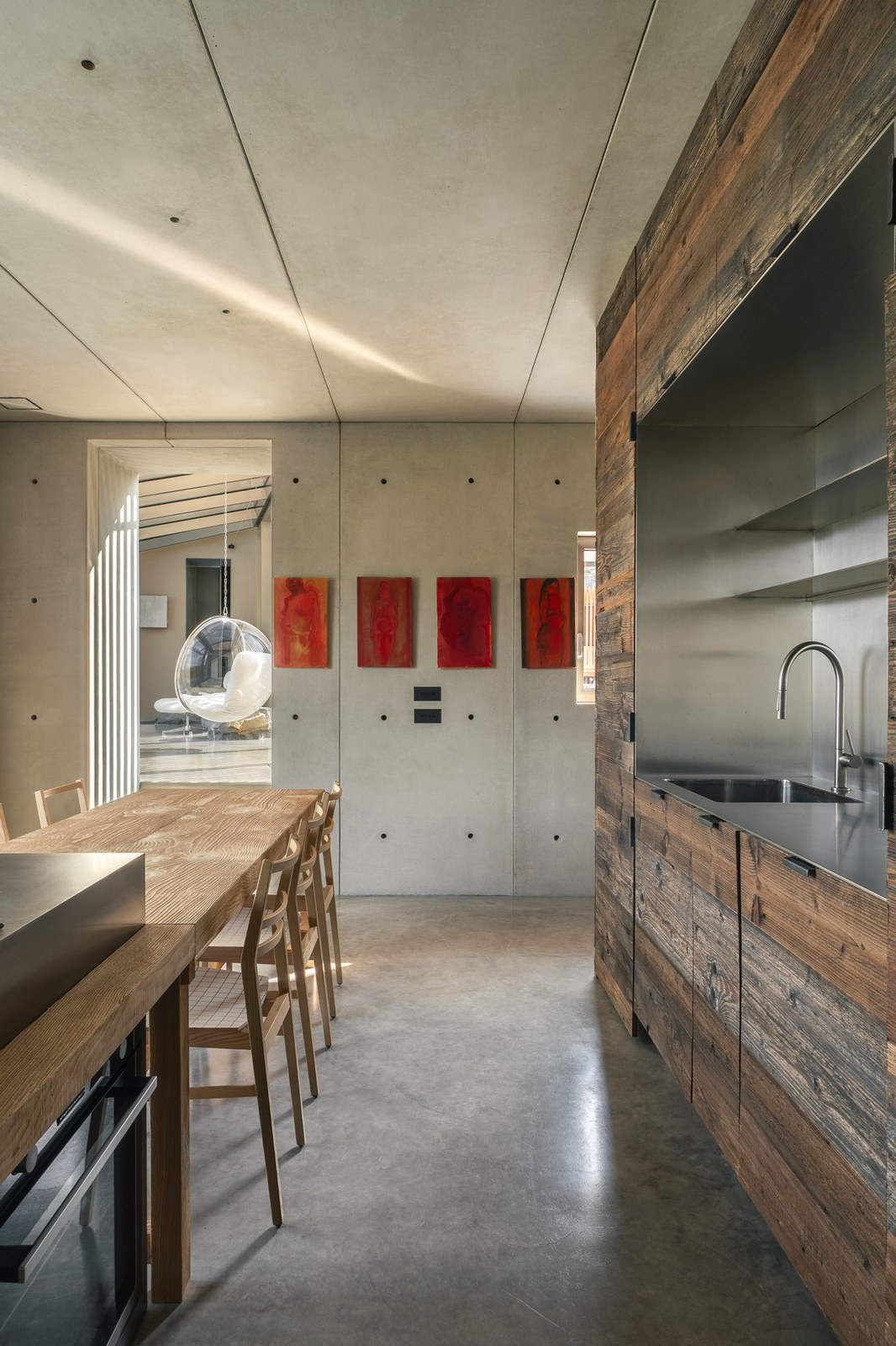 Cucina e tavolo lungo su pavimento in cemento nuvolato, casa Vertigo in Val Trebbia