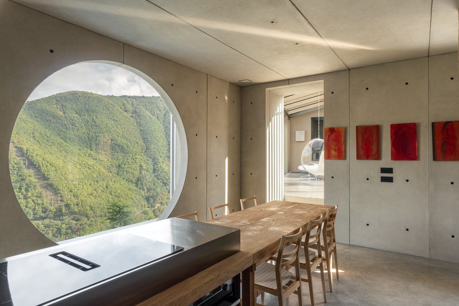 Tavolo da pranzo davanti alla finestra circolare sulla Val Trebbia, pavimento in Nuvolato Architop
