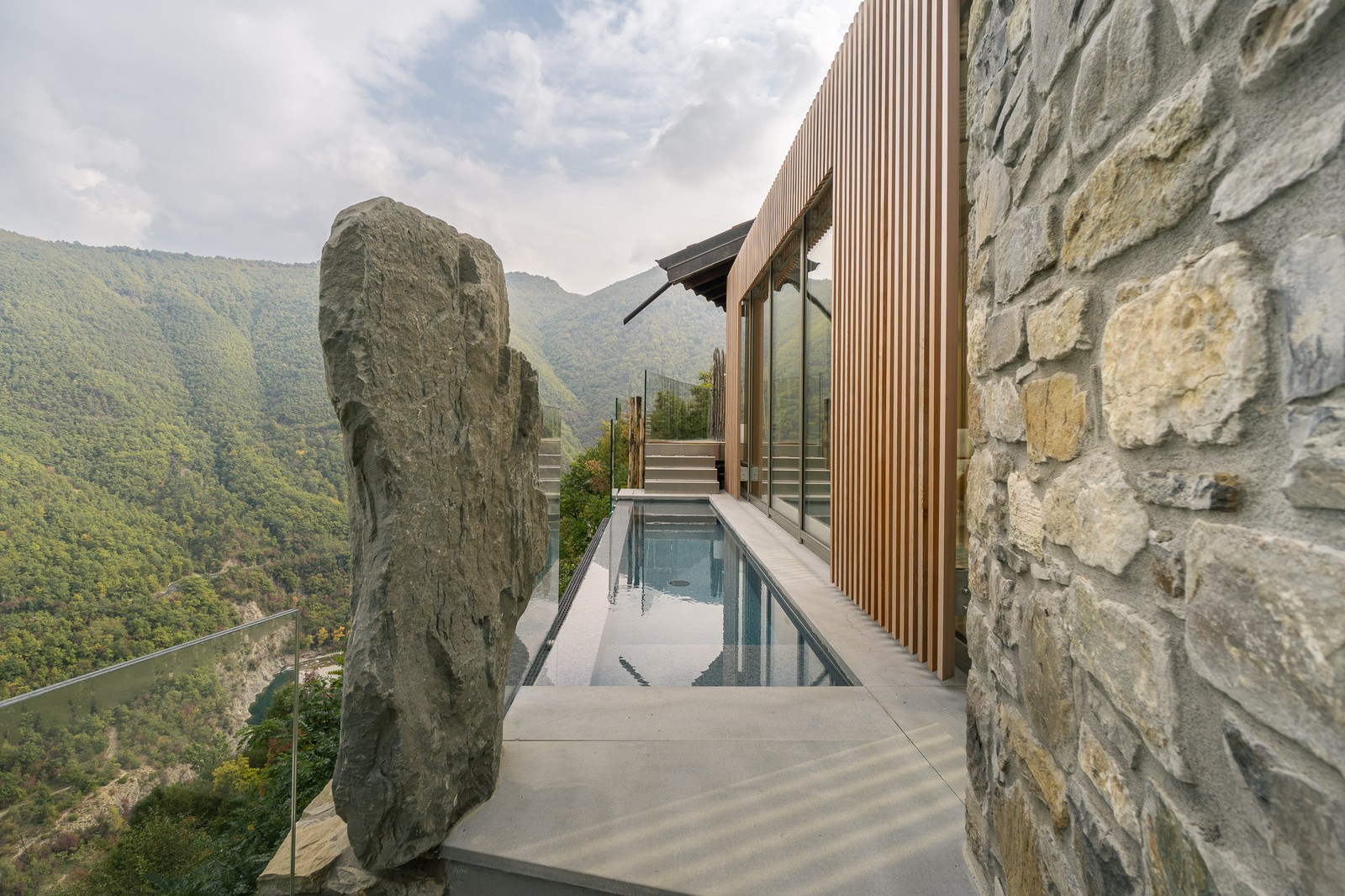 Piscina a sfioro tra la pietra della casa e la valle del Trebbia, progetto Vertigo a Brugnello