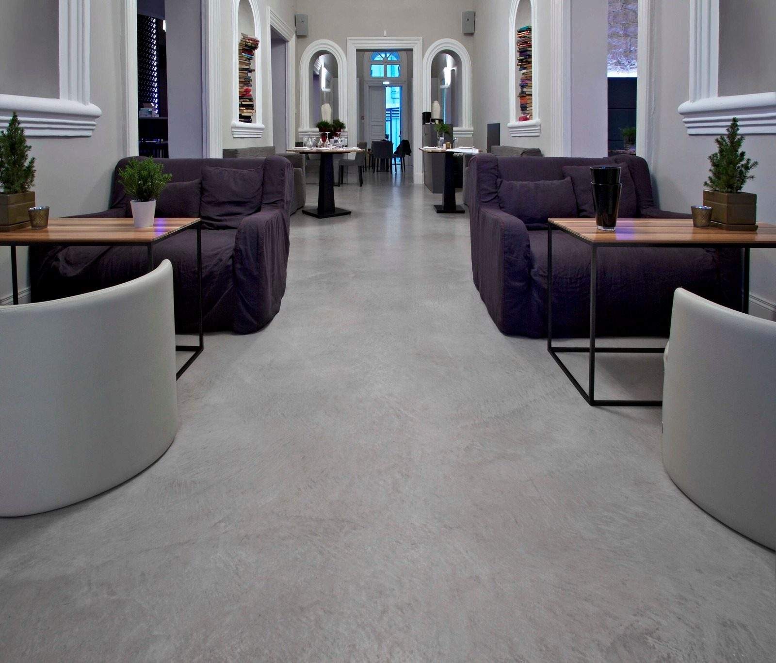 Sala d'attesa con poltrone su un pavimento in microcemento grigio