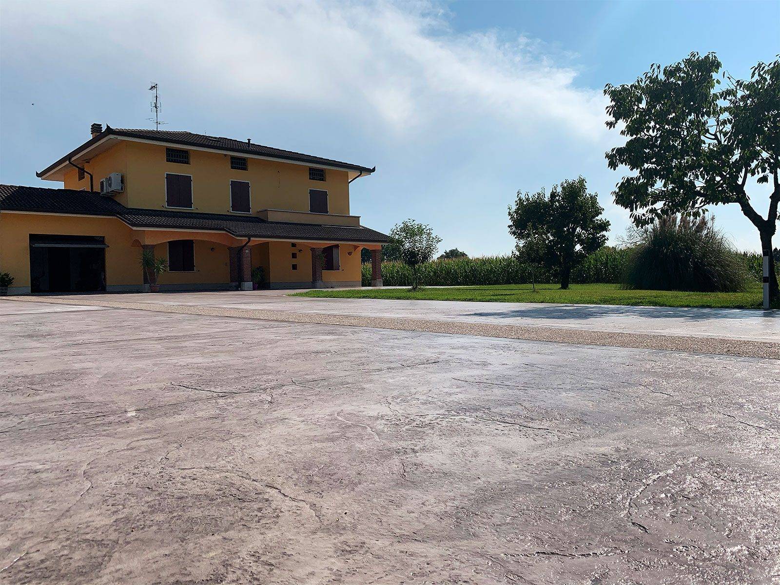 Ampio cortile in cemento stampato davanti a una villa